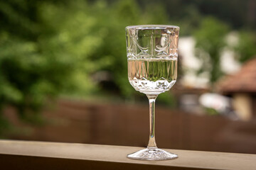 White wine in a decorative glass, summer rural outdoors bg, alcoholic beverage