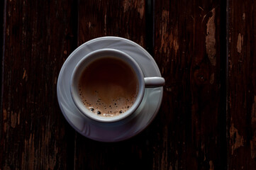 Close-up of a cup with coffee on a wooden table