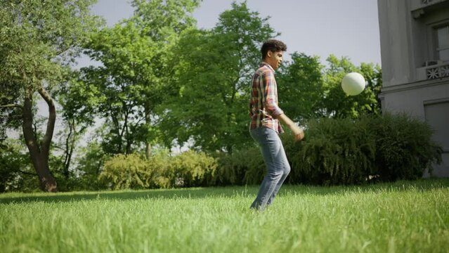 African American guy kicking ball outdoors, healthy lifestyle, exercise