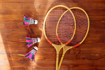 Badminton rackets and shuttlecock on wooden background top view. Badminton concept