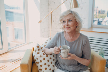 Elderly caucasian old aged woman enjoying afternoon tea at home