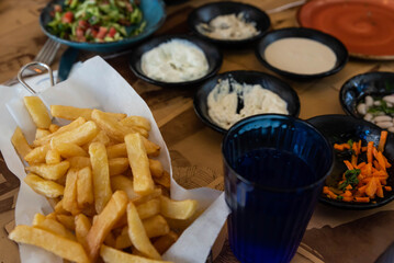Israel and Lebanon cuisine served in restaurant. Middle eastern or Arabic Oriental restaurant. Several appetizer dishes and spreads for bread, potato chips and salad. 