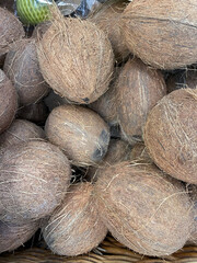 Textured background of brown coconuts. Food market. Selective focus. Vertical photo