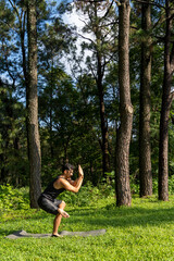 Fototapeta na wymiar young man, doing yoga or reiki, in the forest very green vegetation, in mexico, guadalajara, bosque colomos, hispanic,