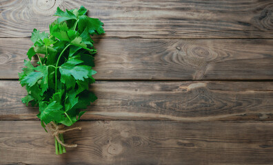 Fresh greens of celery on a wooden background. Top view. Flat lay. Greens for salads and vitamin drinks. Fresh celery