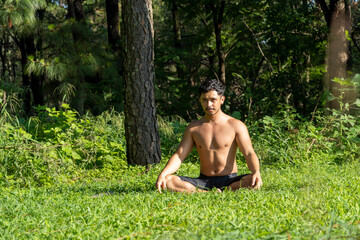 hispanic and latin man, meditating in the middle of a forest, receiving sun rays, brown skin, mexico