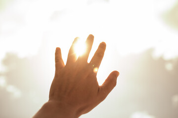 Hand up reaching out to the sunlight. Feeling at peace, worship, salvation concept. 