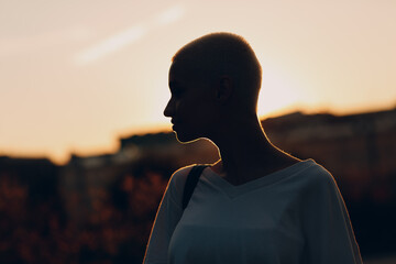 Portrait silhouette profile of young smiling millenial european short haired woman summer sunset....