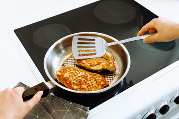 fry chicken or pork meat in batter in pan. Cooking austrian schnitzel at home
