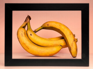 Yellow bananas on nude background with frame border in pop art style food. A modern creative concept of a fruit diet