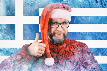 bearded charismatic Greek citizen in Santa hat on frozen background with flag of Greece, concept of crisis in Europe with natural gas in winter, energy crisis and rising energy prices, toned image