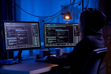 cybercrime, hacking and technology concept - female hacker in dark room writing code or using...