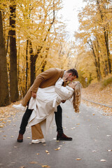 Fototapeta premium Romantic couple walking in autumn forest and kissing