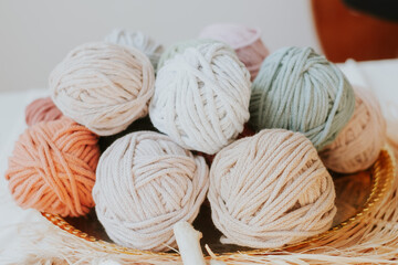 Basket with cozy cotton twine balls. Homely atmosphere. Hobby knitting. Cotton twines in warm...