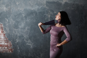 Fototapeta premium Young adult spanish woman dancing flamenco on gray vintage studio background