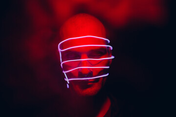 Portrait of man with neon glow lines on his face. Concept cyberpunk and virtual reality