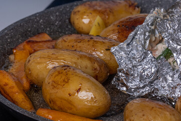 Close-up of appetizing oven baked potatoes on gray pan. Excellent image for homemade food banners and advertisements.
