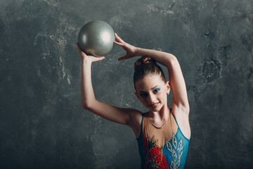 Young girl professional gymnast woman portrait rhythmic gymnastics with ball at studio.