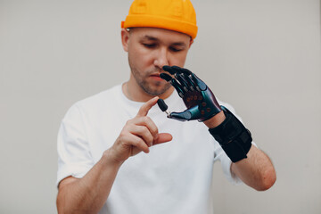 Young disabled man with artificial prosthetic hand put on finger nozzle pad