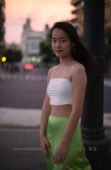 Fototapeta na wymiar Beautiful Asian woman walking the night street of European city while traveling. Tourist from China exploring. Diverse people and tourism in Europe, fashion and style concept.