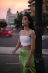 Beautiful Asian woman walking the night street of European city while traveling. Tourist from China exploring. Diverse people and tourism in Europe, fashion and style concept.