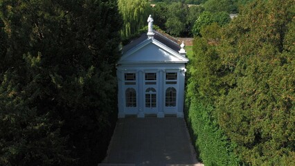 Aerial top down view from the drone onto the narrow passageway leading to a small chapel. Chapel located in a big green open area of fields near Rosary Manor, Mill Hill, North West London, London, UK.