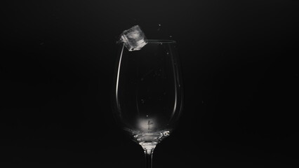 Frozen blocks falls empty glass closeup. Refreshing cocktail preparation concept