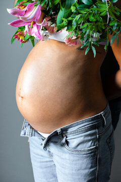 Pregnant Woman with flowers, close-up of belly