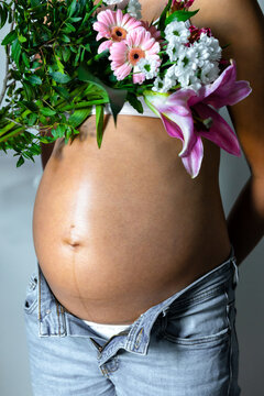 Pregnant Woman with flowers, close-up of belly