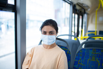 Fototapeta na wymiar Indian Woman ride in public transport bus or tram in medical face mask