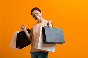 Indian woman holds shopping bags in hands. Sale and Black Friday concept