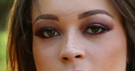 Woman macro eyes closeup looking to camera. Pretty millennial girl face detail