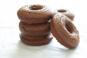 Three stacked homemade chocolate cake donuts.