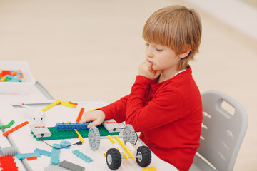 Little boy kid child constructor checking technical toy. Children Robotics constructor assemble robot