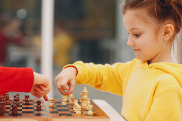 Little kids playing chess at kindergarten or elementary school.