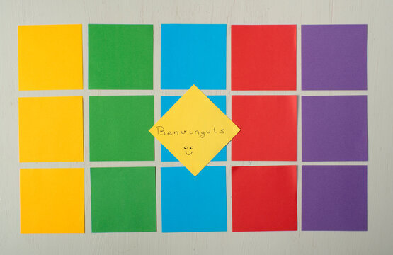 Conjunto de post-it de colores ordenados, en el centro un post-it amarillo con la palabra  Benvinguts, bienvenido en catal&aacute;n