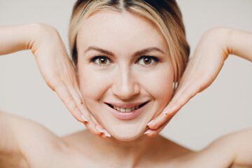 Young adult doing facial gymnastics self massage and rejuvenating exercises face building and...