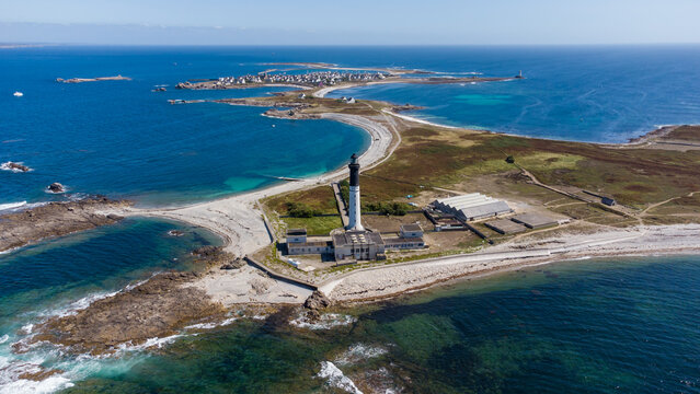 Great lighthouse of the Island of Sein in Brittany, France, in the Atlantic Ocean - Small flat isolated island with a black and white, tall and round lighthouse