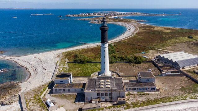 Great lighthouse of the Island of Sein in Brittany, France, in the Atlantic Ocean - Small flat isolated island with a black and white, tall and round lighthouse