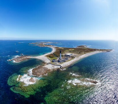 Great lighthouse of the Island of Sein in Brittany, France, in the Atlantic Ocean - Small flat isolated island with a black and white, tall and round lighthouse