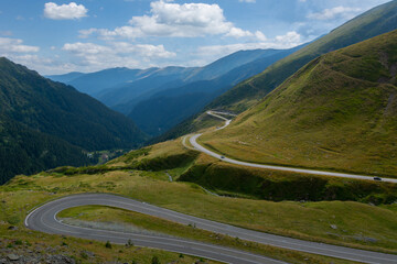 Sunny summer day over Transfagarasan road in Romania. Blue sky with clouds and a spectacular view