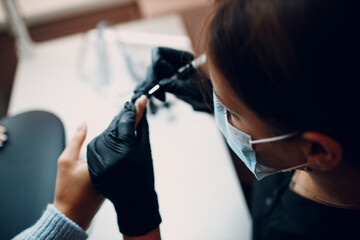 Manicure process female hands finger nails polish.