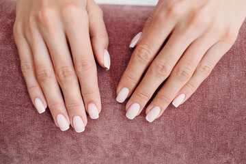 Female hand fingers nails with manicure after nail salon procedure.