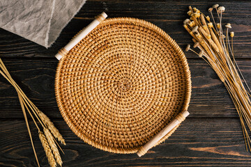 Wicker plate made of straw on a wooden background. view from above
