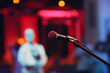 microphone without people on stage with colorful lights of stand-up show Concept.