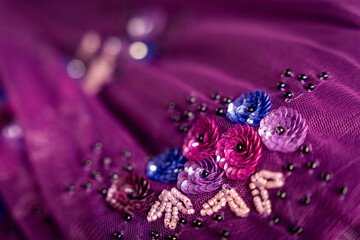 Purple mesh fabric with sequin and glass bead flowers texture bg