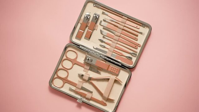 Pastel cosmetic set for nail care in a case placed on a pink background