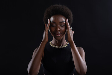 Close up portrait of young african american black woman doing facebuilding yoga face gymnastics...
