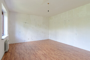 A fragment of the interior of a spacious empty room with a fine finish of the walls