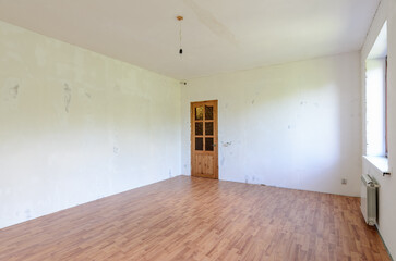 A fragment of the interior of a spacious room with a fine finish, view of the front door